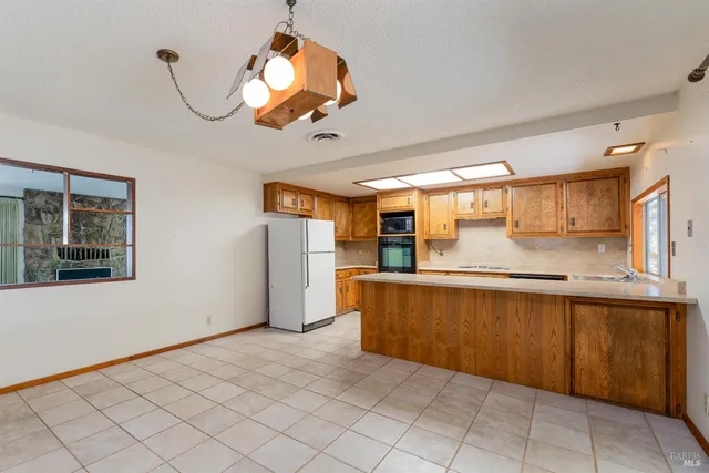 a view of a kitchen with a sink and dishwasher a refrigerator with wooden floor