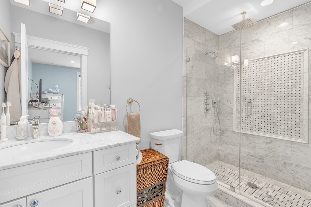 199 West 8th Street, Unit 6 Boston, MA 02127 - Photo 16 of 28 a bathroom with a granite countertop toilet a sink and a mirror