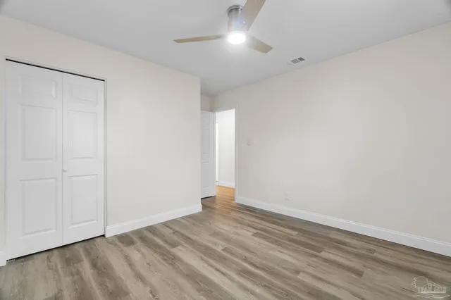 a view of empty room with wooden floor
