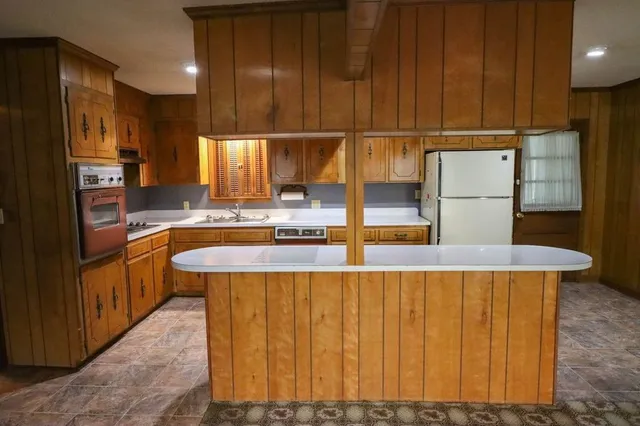 a kitchen with a table chairs refrigerator and cabinets