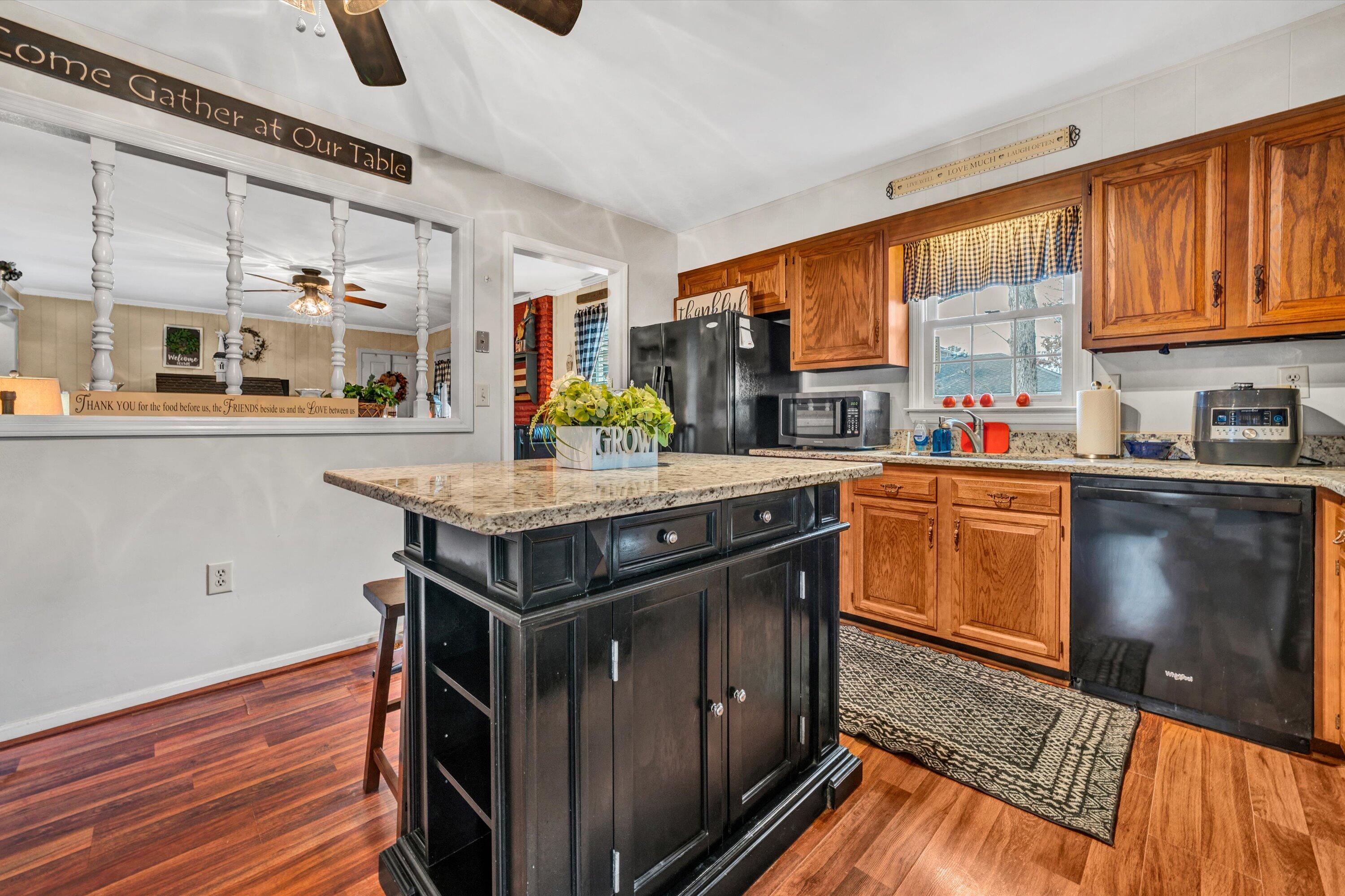 87 Queen Regent Court Blue Ridge, VA 24064 - Photo 14 of 38 a kitchen with kitchen island granite countertop a sink cabinets and wooden floor