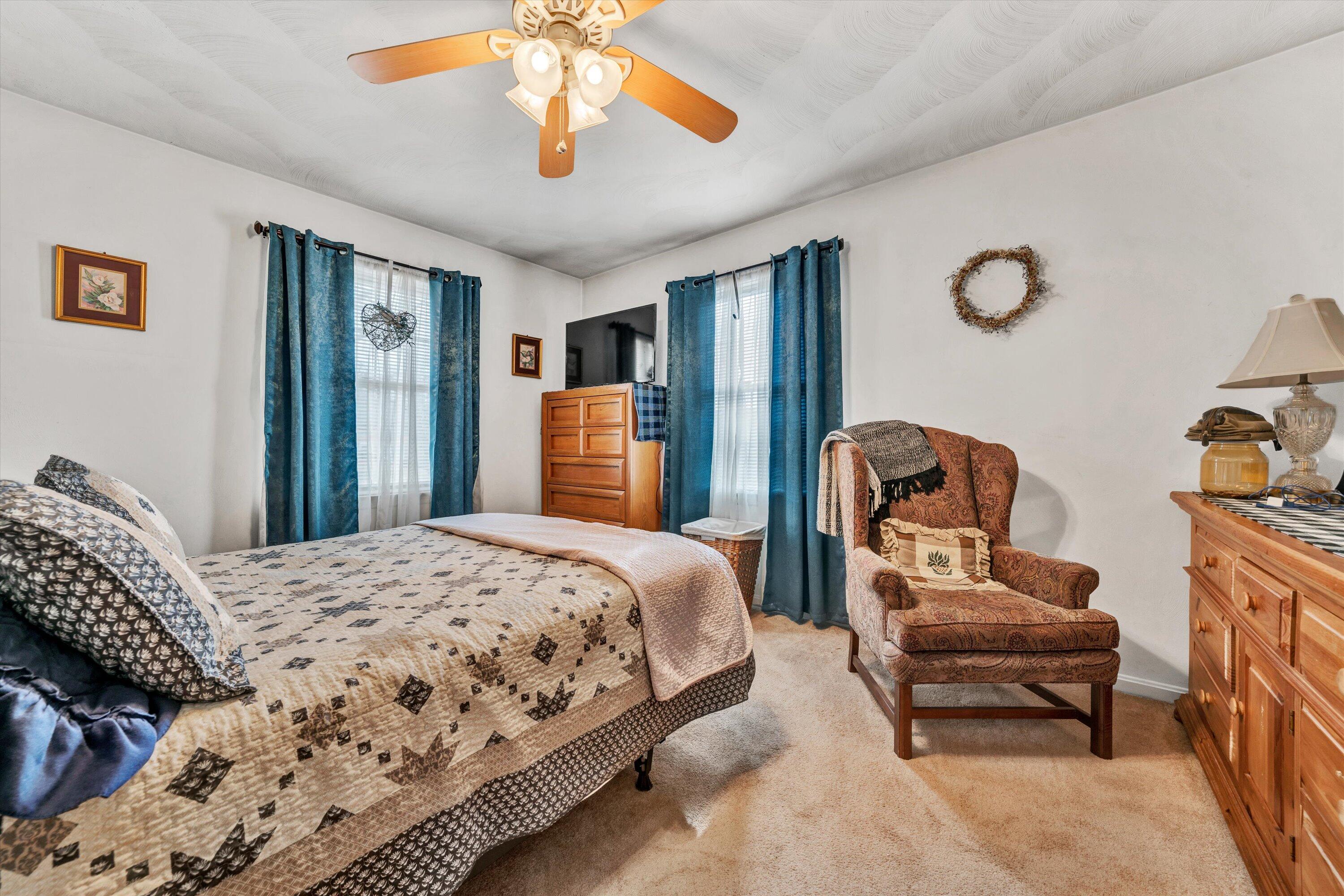 87 Queen Regent Court Blue Ridge, VA 24064 - Photo 18 of 38 a bedroom with a bed and a chandelier