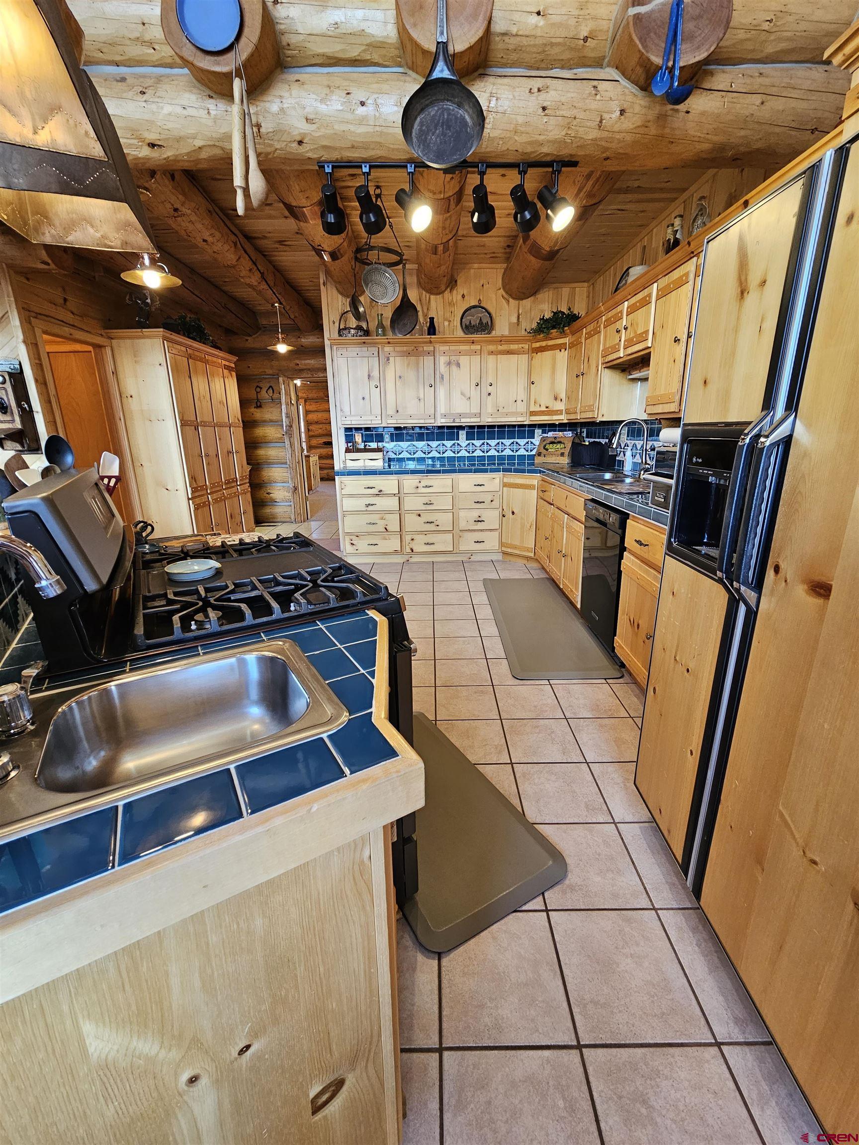 212 Pleasant Drive Ridgway, CO 81432 - Photo 13 of 35 a kitchen with granite countertop a stove a sink and a microwave