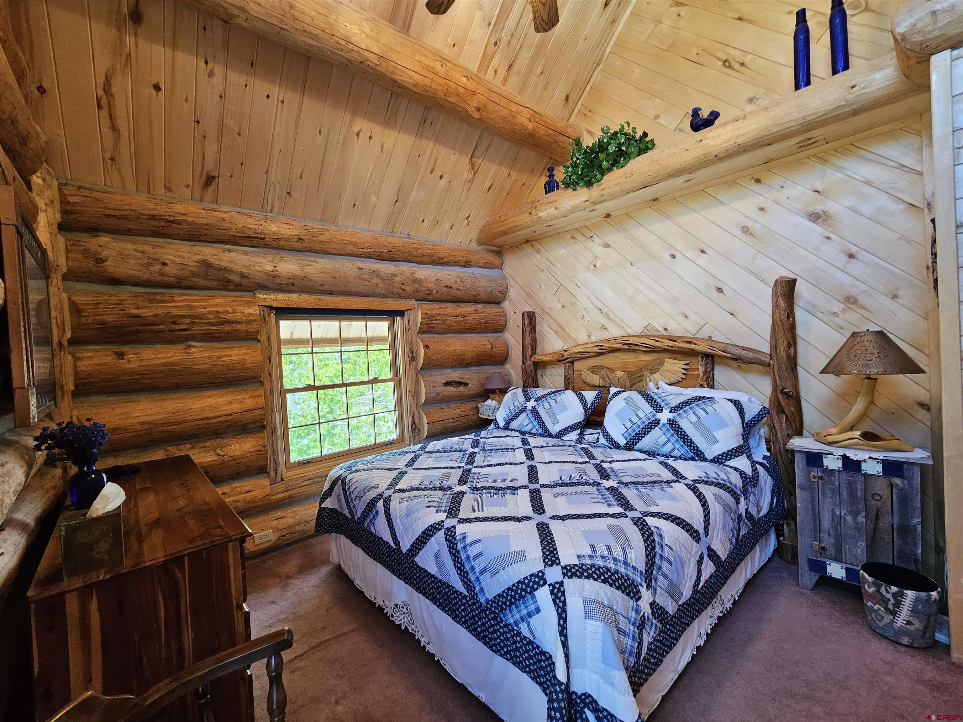 212 Pleasant Drive Ridgway, CO 81432 - Photo 23 of 35 a bedroom with a bed a dresser with wooden floor