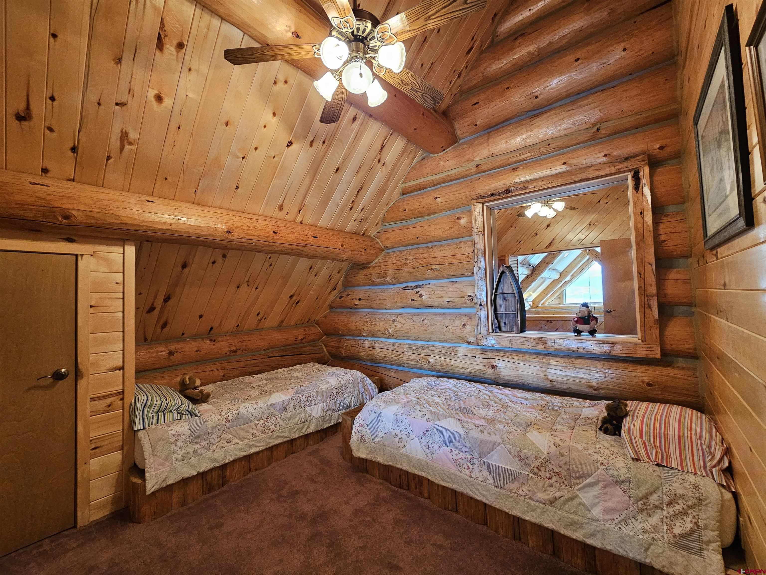 212 Pleasant Drive Ridgway, CO 81432 - Photo 24 of 35 a bedroom with a bed and wooden floor