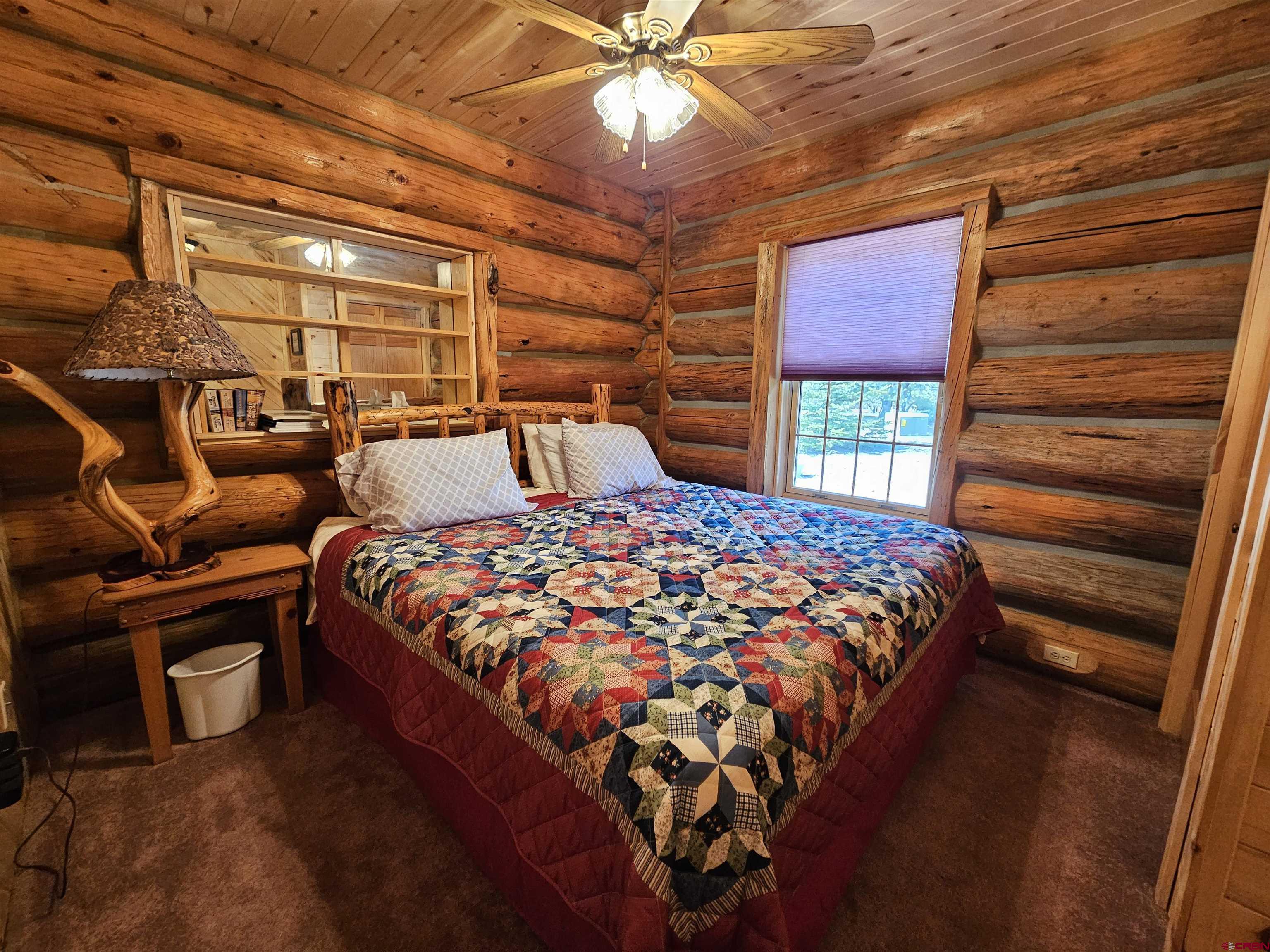 212 Pleasant Drive Ridgway, CO 81432 - Photo 30 of 35 a bed sitting in a bedroom next to a window