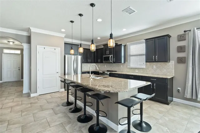 a living room with furniture a chandelier and a flat screen tv