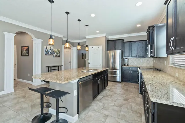 a large kitchen with granite countertop lots of counter space and stainless steel appliances