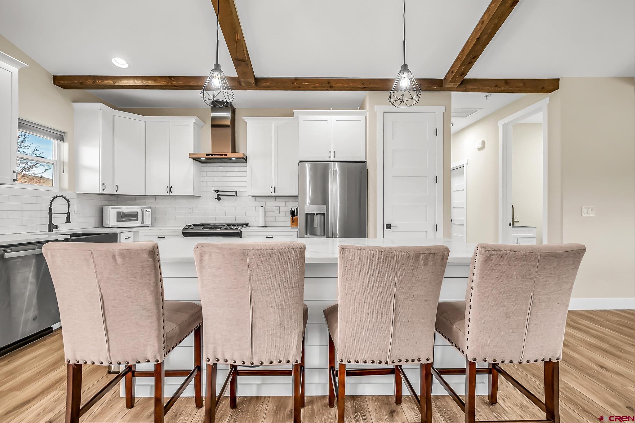 3337 Congress Street Montrose, CO 81401 - Photo 11 of 33 a kitchen with stainless steel appliances granite countertop a dining table chairs and a refrigerator