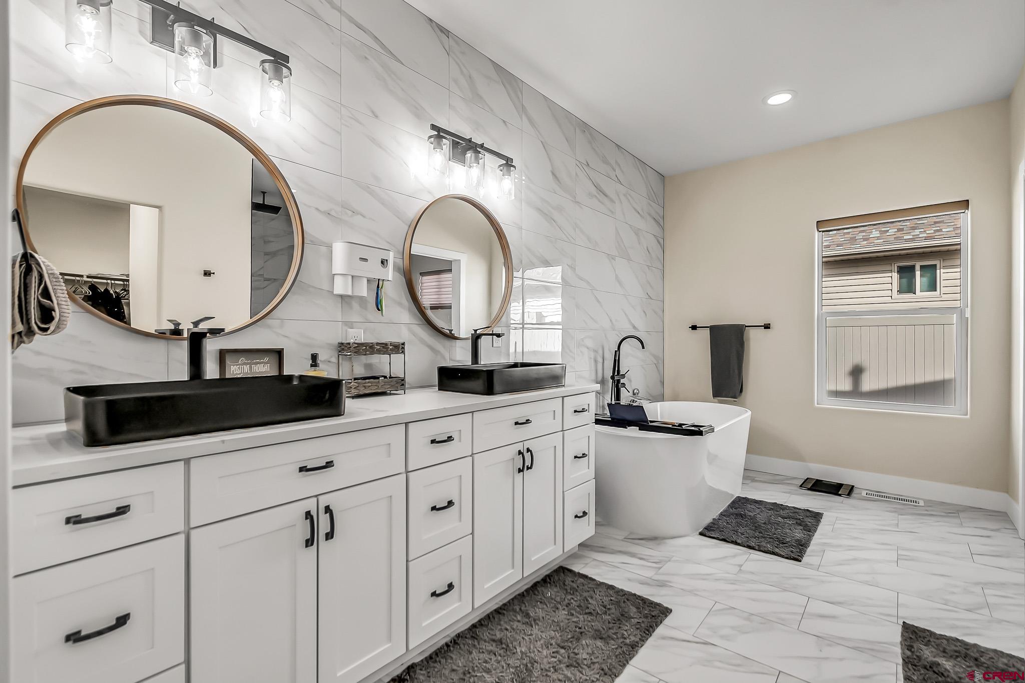 3337 Congress Street Montrose, CO 81401 - Photo 16 of 33 a spacious bathroom with a double vanity sink and a mirror