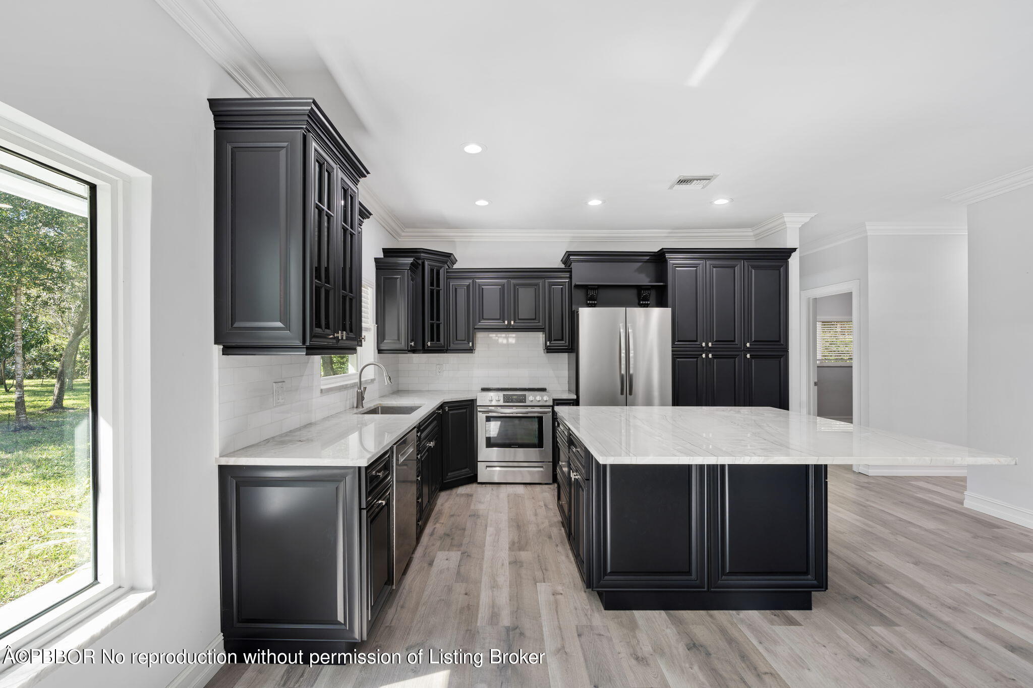 5608 Old Fort Jupiter Road Jupiter, FL 33458 - Photo 12 of 59 a large kitchen with a large counter top a sink stainless steel appliances and cabinets