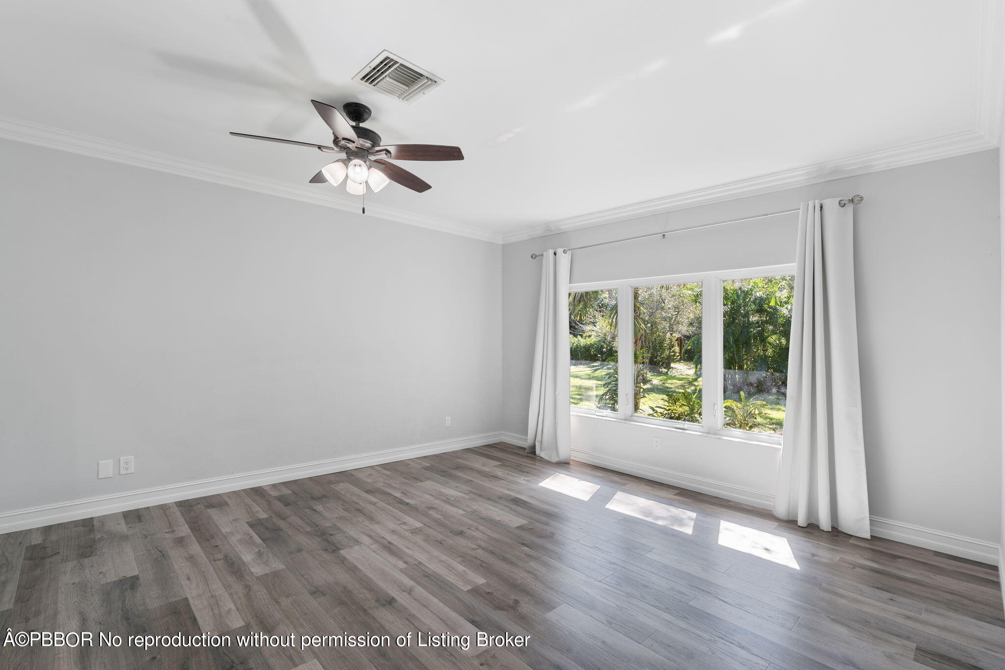 5608 Old Fort Jupiter Road Jupiter, FL 33458 - Photo 19 of 59 an empty room with wooden floor fan and windows