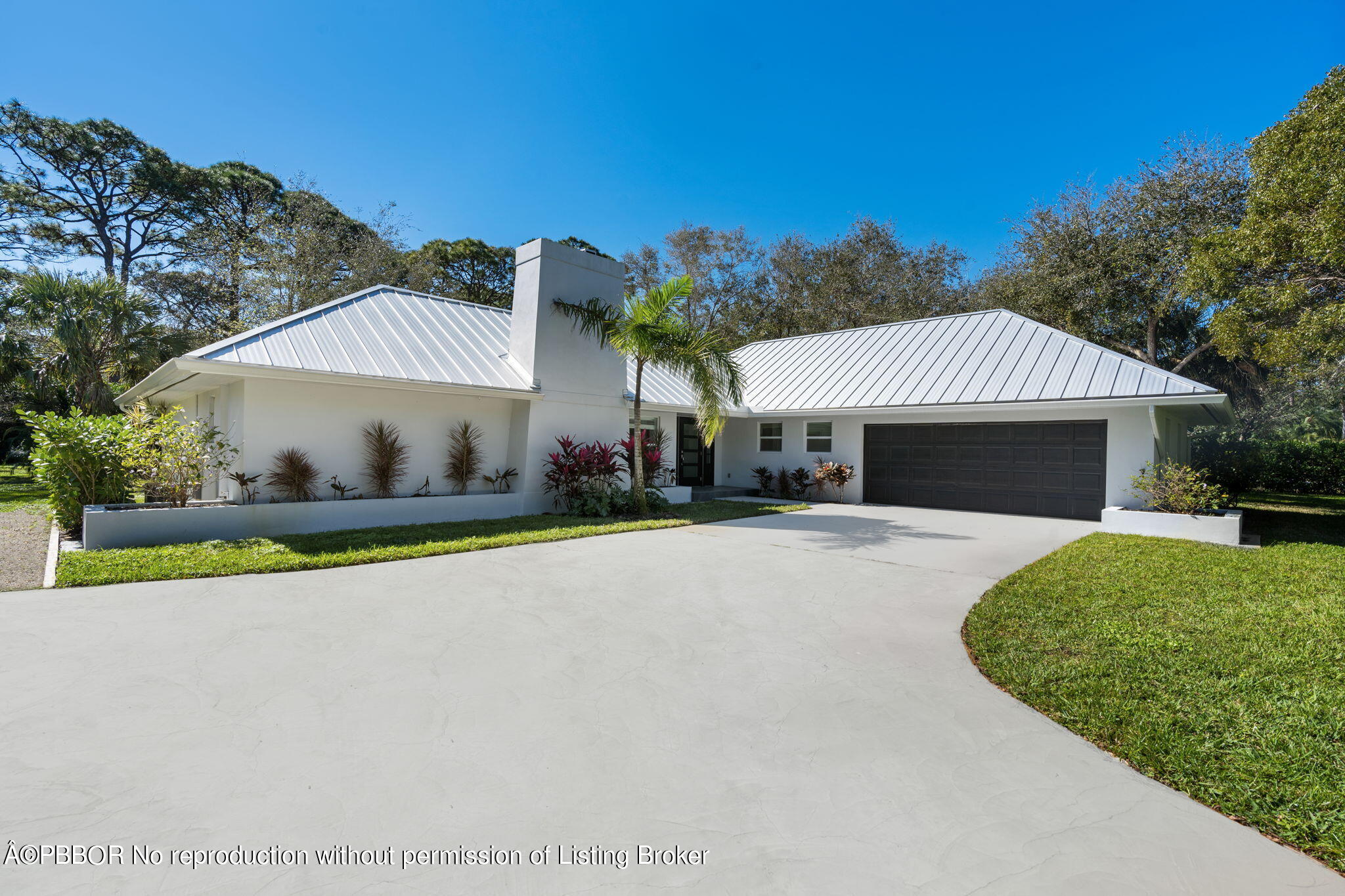 5608 Old Fort Jupiter Road Jupiter, FL 33458 - Photo 3 of 59 a front view of a house with a yard and garage