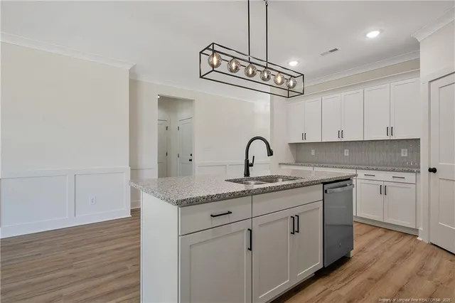 a kitchen with stainless steel appliances granite countertop a sink and cabinets