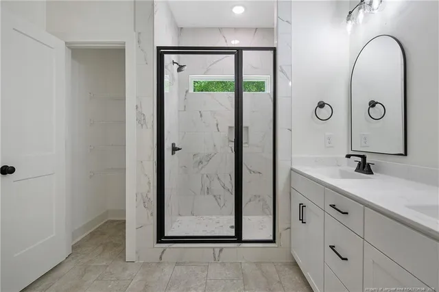 a bathroom with a granite countertop sink a mirror and shower