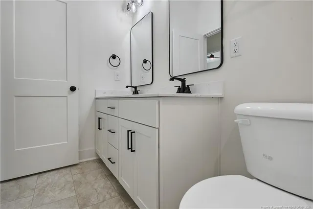a bathroom with a toilet a sink and mirror