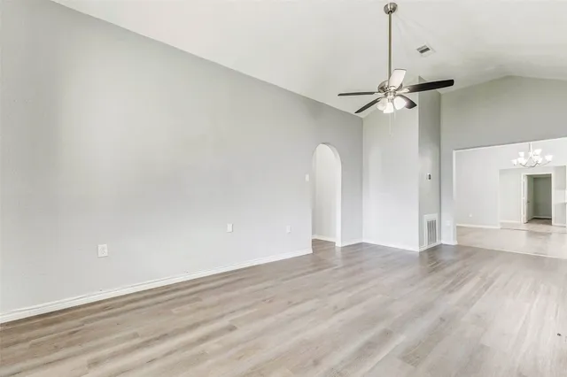 a view of empty room with wooden floor and ceiling fan