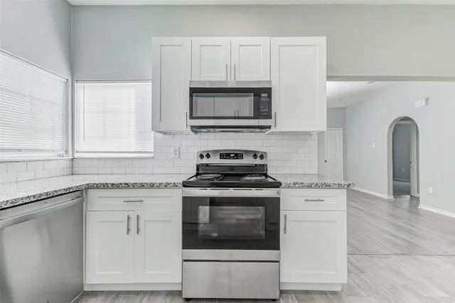 a kitchen with granite countertop a stove and a sink