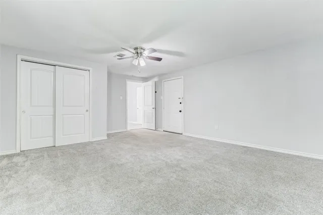 a view of an empty room with a ceiling fan