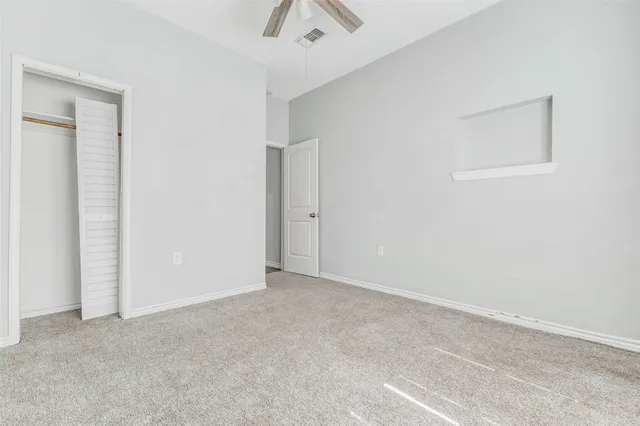 an empty room with fan and entrance