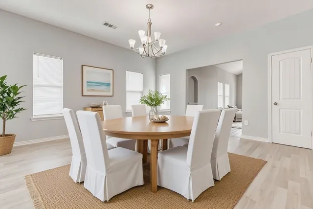 a view of a dining room with furniture and chandelier