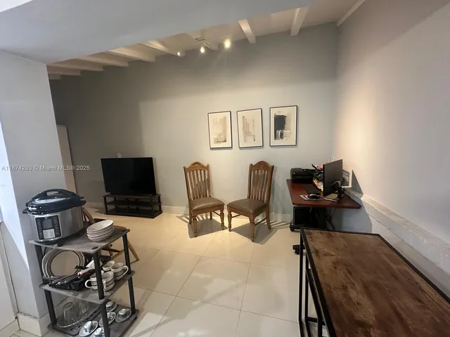 a living room with furniture a flat screen tv and large window