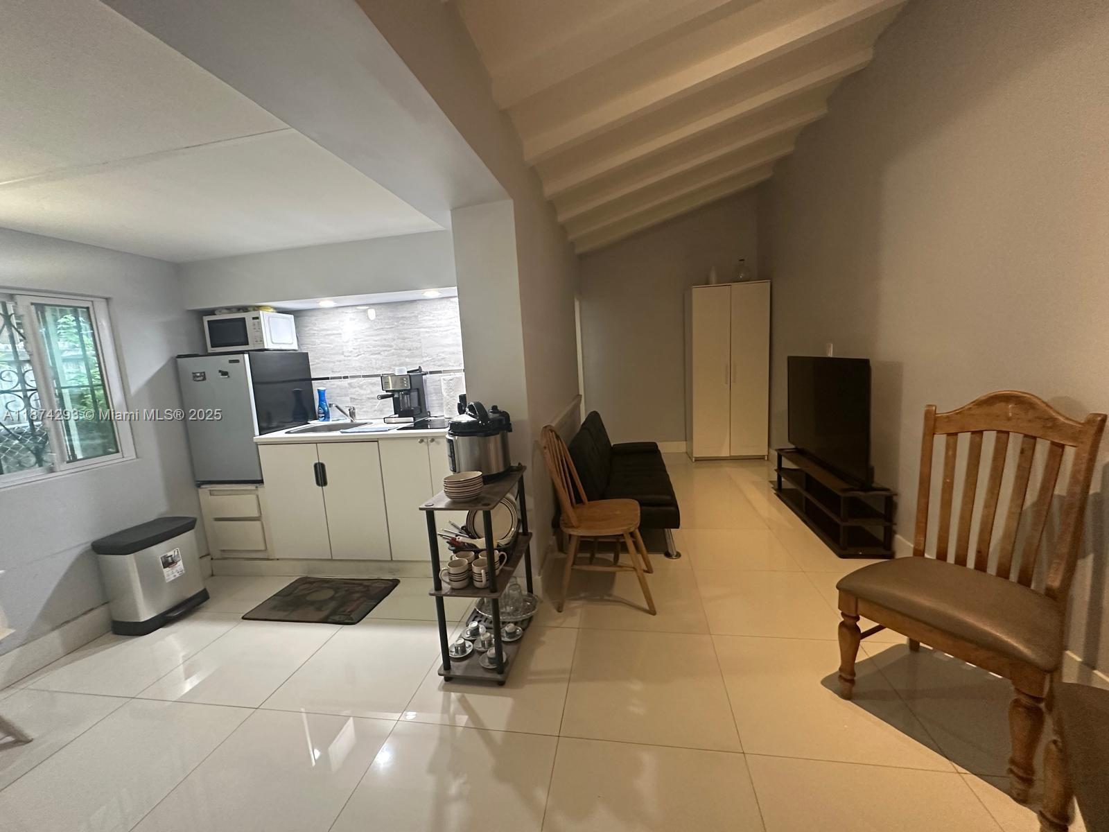 324 Southwest 23rd Avenue, Unit 2 Miami, FL 33135 - Photo 3 of 8 a living room with furniture a flat screen tv and large window