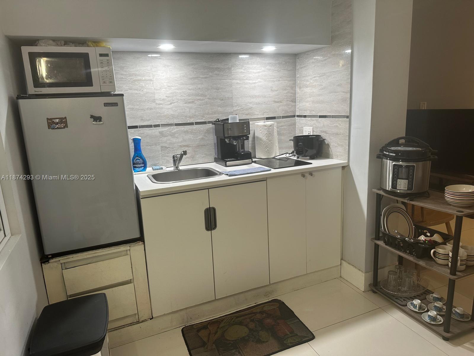 324 Southwest 23rd Avenue, Unit 2 Miami, FL 33135 - Photo 5 of 8 a kitchen with a sink a refrigerator and cabinets