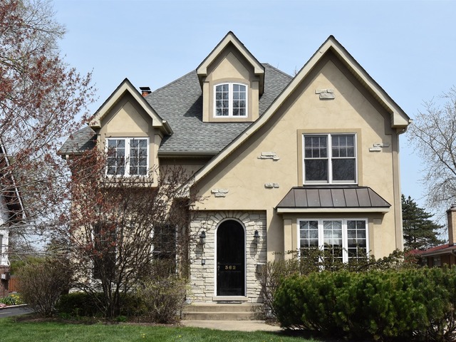 a front view of a house with yard and trees