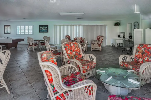 a living room with furniture kitchen view and a window
