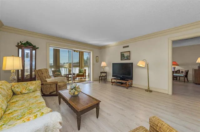 a living room with furniture flat screen tv and large window