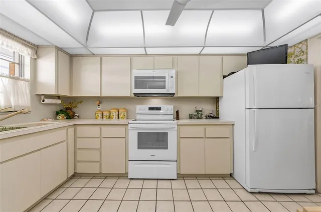 a kitchen with cabinets appliances a sink and a window