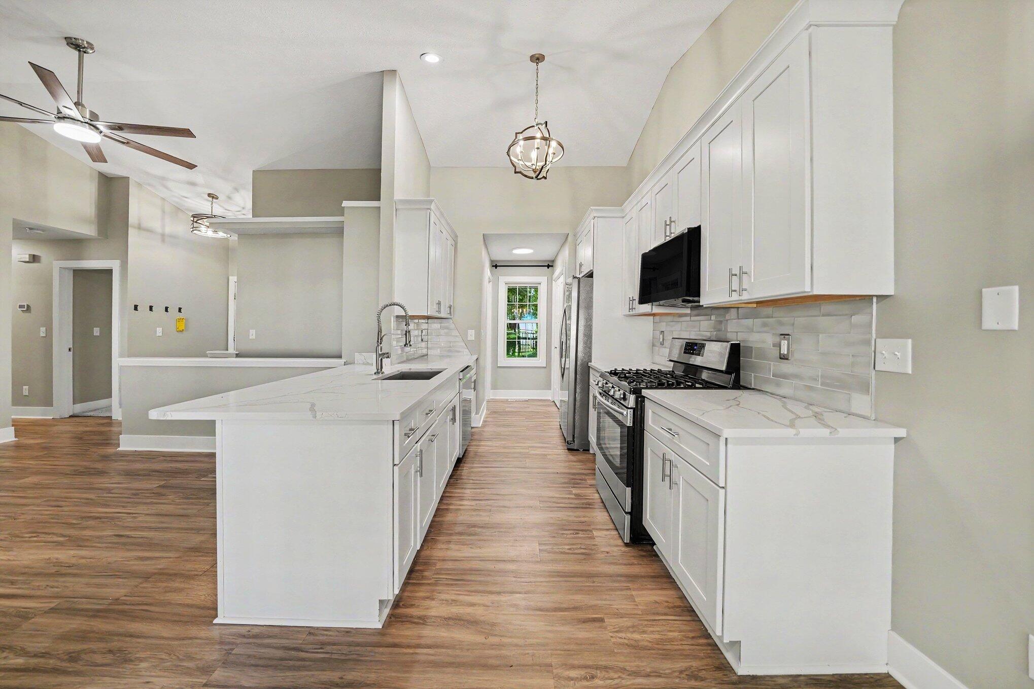 7563 East 400 North Rolling Prairie, IN 46371 - Photo 6 of 17 a large kitchen with kitchen island lots of counter space a sink appliances and cabinets
