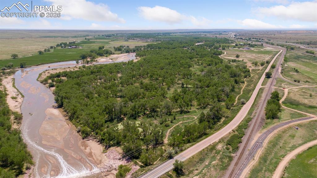 16880-1688 Old Pueblo Road Fountain, CO 80817 - Photo 2 of 47 Aerial view highlighting Fountain Creek frontage, mature cottonwood corridors, and adjacent roadway access, emphasizing the property’s natural setting and connectivity within the surrounding landscape.