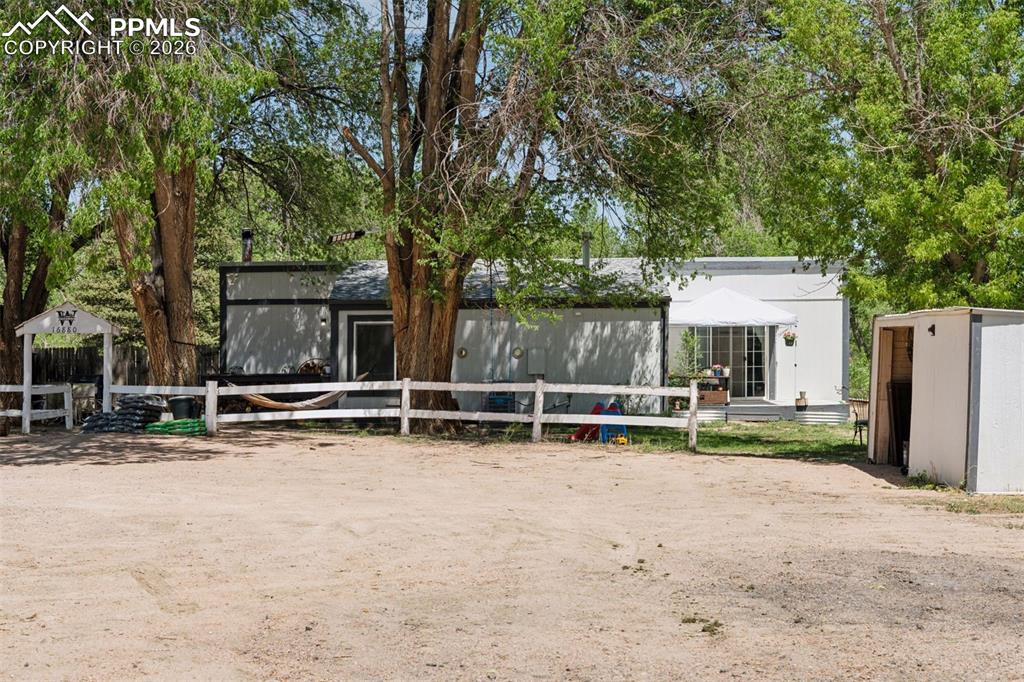 16880-1688 Old Pueblo Road Fountain, CO 80817 - Photo 21 of 47 Exterior view of the second single-family residence featuring a 3-bedroom, 1-bath layout, set among mature trees on the property.