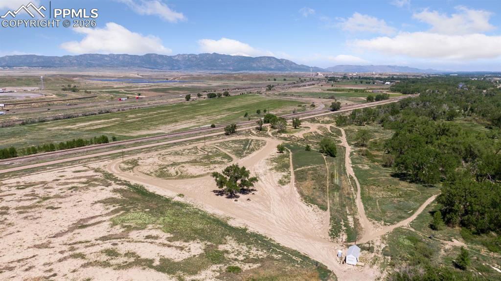 16880-1688 Old Pueblo Road Fountain, CO 80817 - Photo 3 of 47 Elevated aerial showcasing the entrance/base area of the established Fountain Motorsports Park and riding trail system, predominantly level terrain, and expansive views toward the Front Range, illustrating the recreational scale of the land.