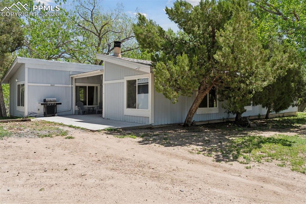 16880-1688 Old Pueblo Road Fountain, CO 80817 - Photo 8 of 47 Additional exterior view of the primary single-family residence with covered patio and mature trees.
