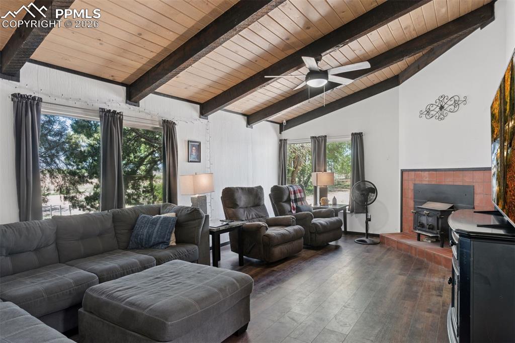 16880-1688 Old Pueblo Road Fountain, CO 80817 - Photo 9 of 47 Interior living area of 16885 featuring vaulted wood ceilings with exposed beams, natural light, and a wood-burning stove