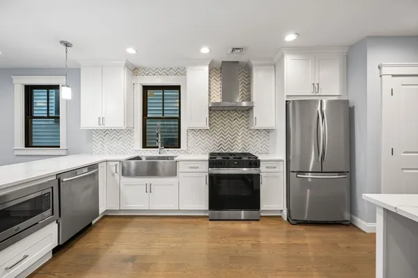 a kitchen with stainless steel appliances granite countertop a refrigerator oven a sink and dishwasher