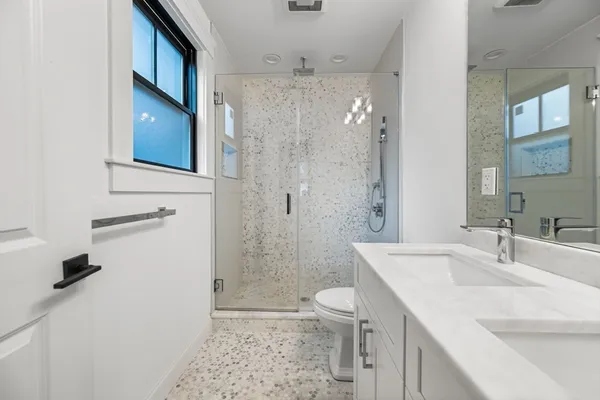 a bathroom with a sink a toilet and shower