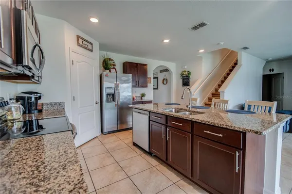 a kitchen with stainless steel appliances granite countertop a sink and a refrigerator