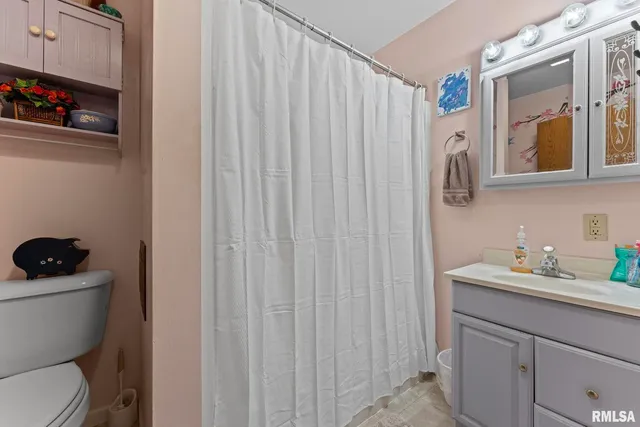 a bathroom with a sink a toilet and shower curtain