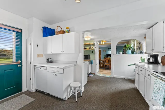 a kitchen with white cabinets and white appliances