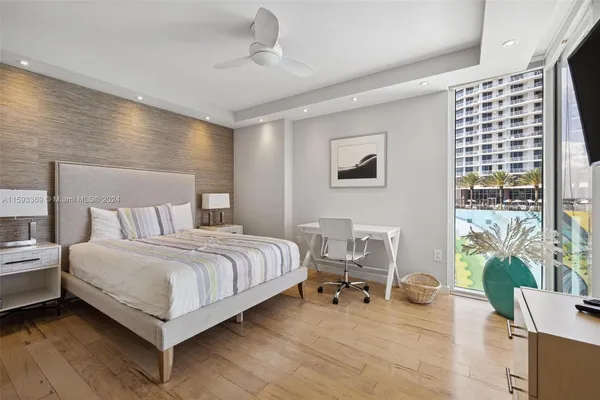 a large bedroom with a large bed and flat tv