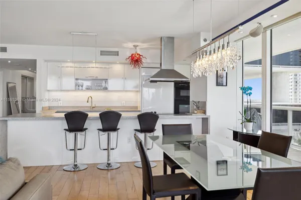 a kitchen with stainless steel appliances kitchen island granite countertop a table and chairs in it