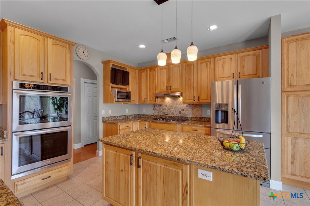 2235 Summit Ridge San Marcos, TX 78666 - Photo 13 of 38 a kitchen with granite countertop a sink stainless steel appliances and cabinets