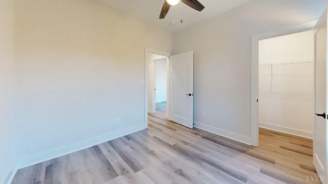 an empty room with wooden floor cabinet and a window