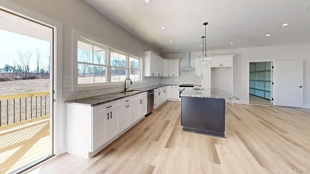a large kitchen with stainless steel appliances granite countertop a lot of counter space and wooden floors