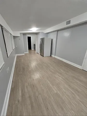 a view of empty room with wooden floor