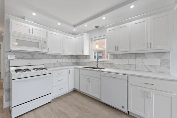 a kitchen with cabinets appliances a sink and a counter top space